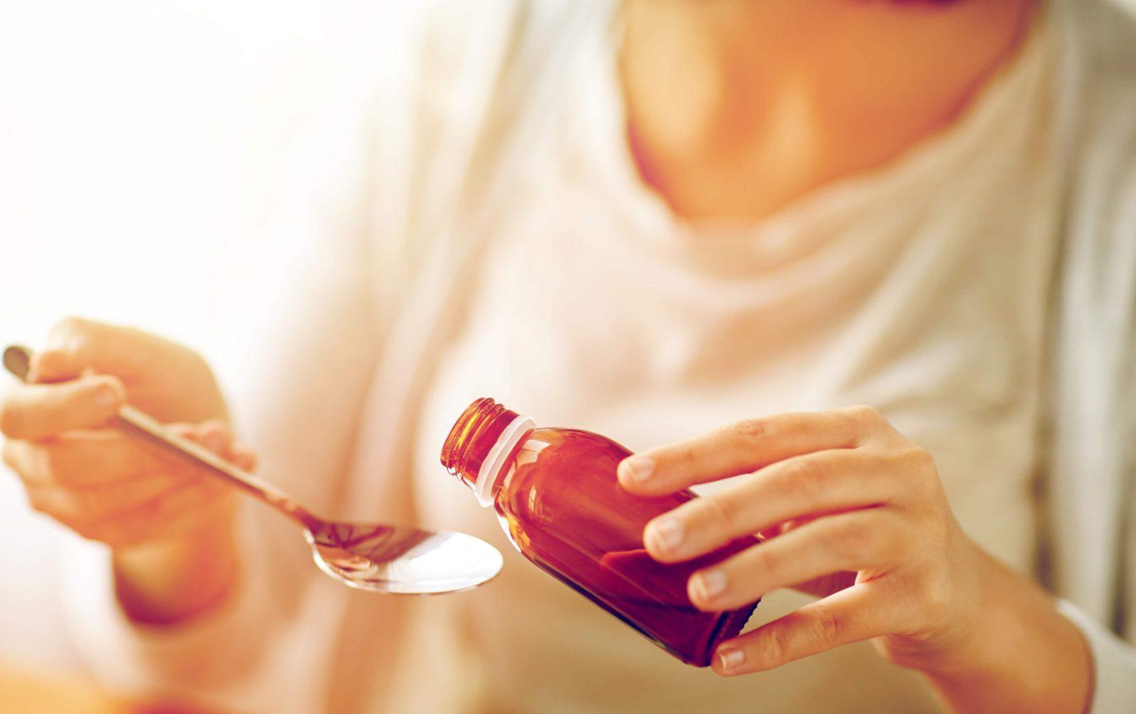 woman pouring medicine from bottle to spoon p3memth min